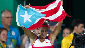 Monica Puig of Puerto Rico celebrates holding her country's flag after winning the gold medal match in the women's tennis competition at the 2016 Summer Olympics in Rio de Janeiro, Brazil, Saturday, Aug. 13, 2016. (AP Photo/Vadim Ghirda)